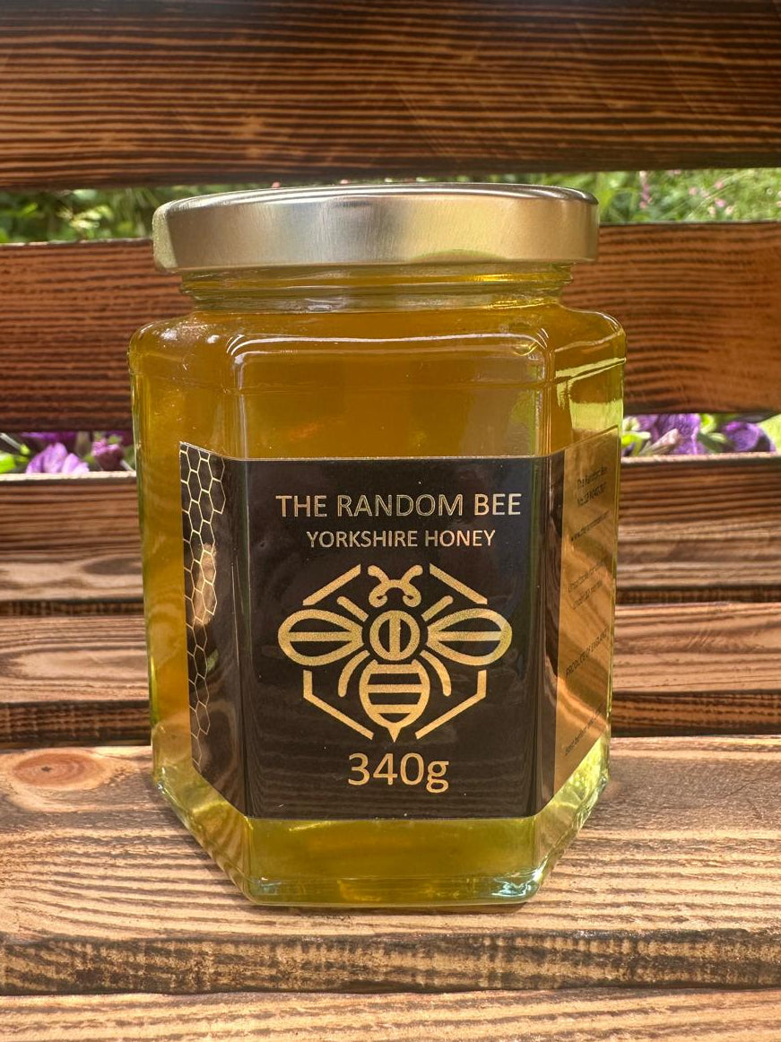 Jar of 340g Yorkshire honey from The Random Bee on a wooden surface with blurred background
