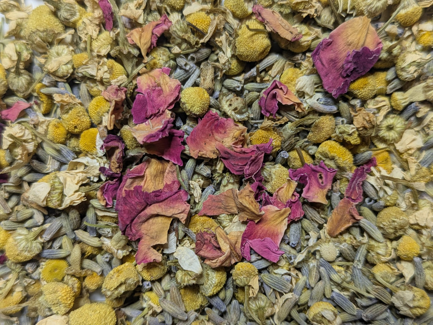Assorted dried herbs and flowers including rose, Chamomile, and Lavender petals.