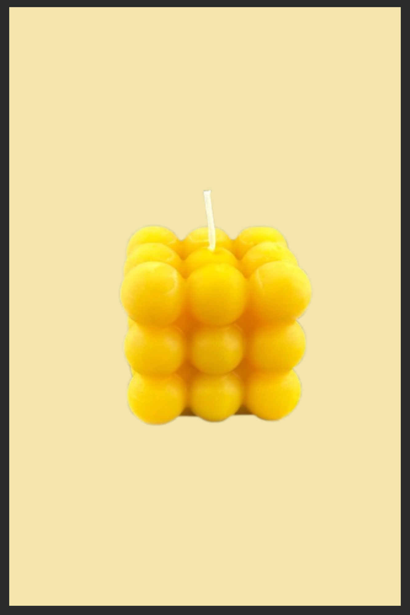 Yellow bubble candle on a beige background